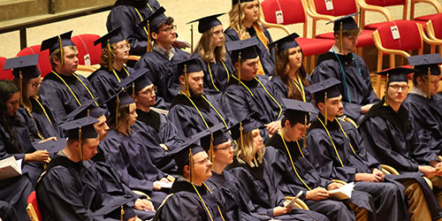 Students in caps and gowns sit at 2026 commencement ceremony.