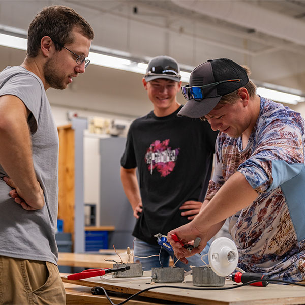 Three electrical students wiring a test light.