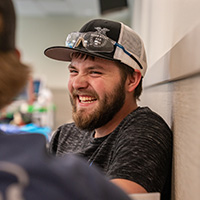 An NICC student smiling while talking with other students.