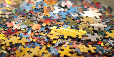 A collection jigsaw puzzle pieces scattered on a table.