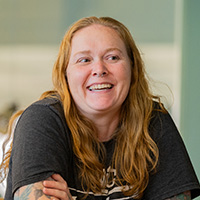 An NICC student smiling while sitting at a table.