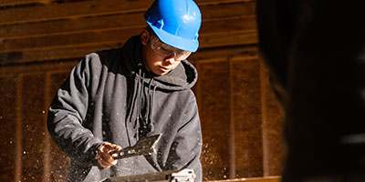 Construction student using saw