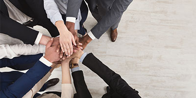 Business people with hands in a pile