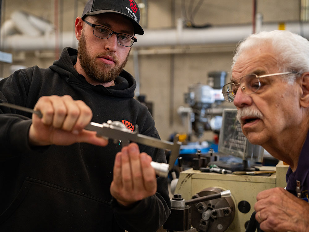 Student and teacher work on mechanical parts