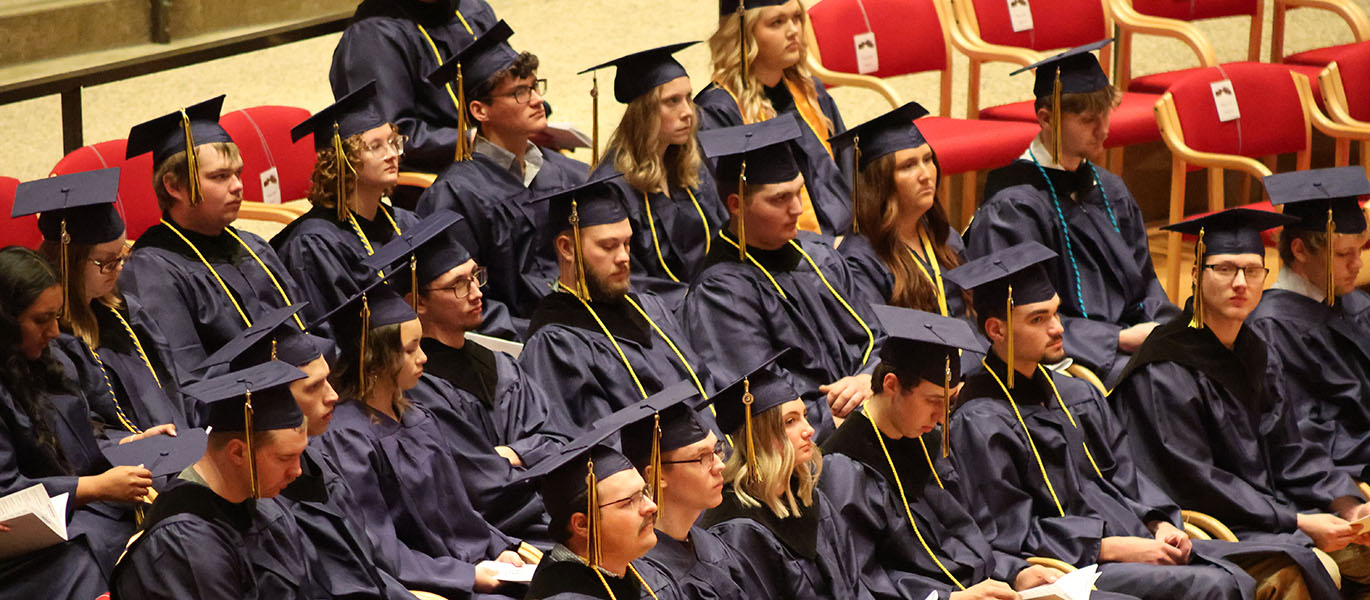 Students in caps and gowns sit at 2026 commencement ceremony.