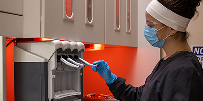 A Dental Assisting student uses the sterilization equipment in the lab.