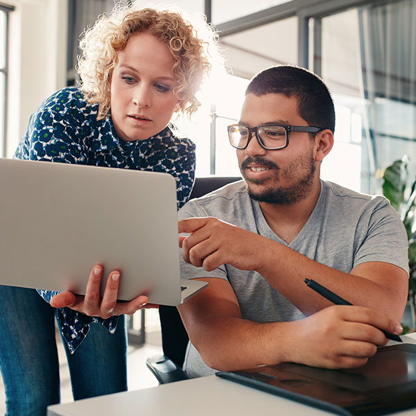 Female and male employees looking at a laptop together