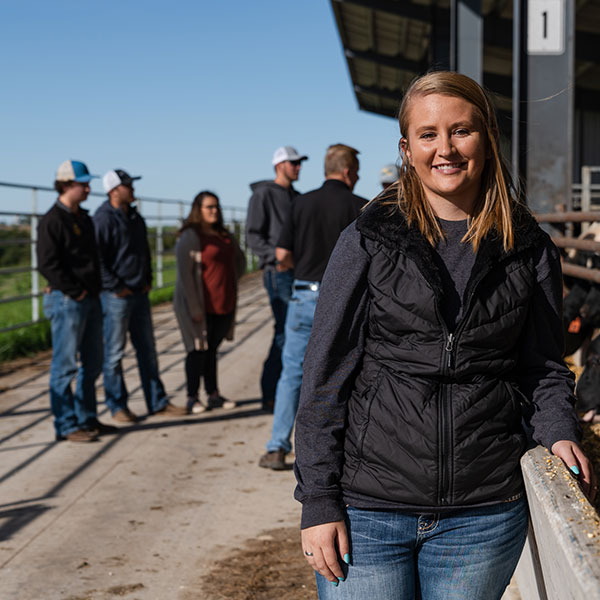 Female Ag student stands in front of her class by the Beef Barn