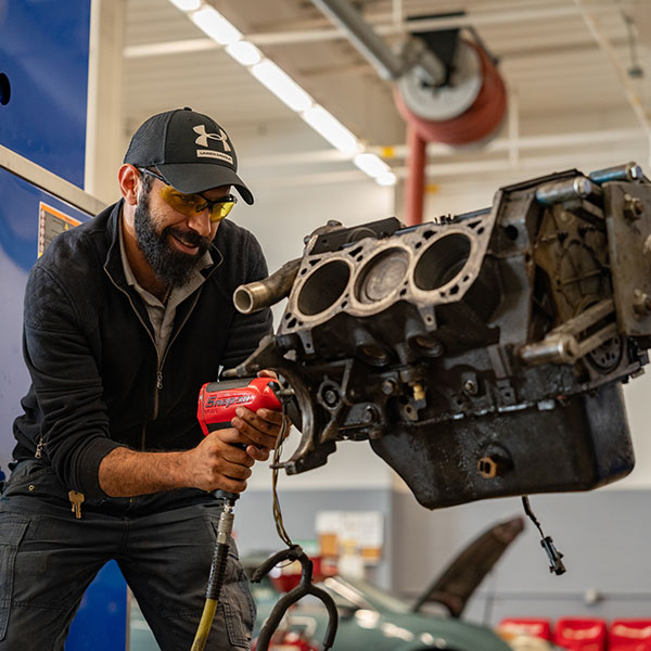 Male Auto student working on an engine