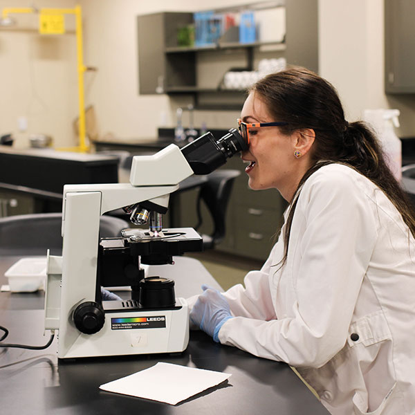 Female student working with a microscope