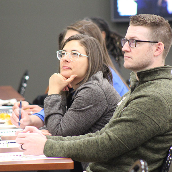 Business professionals listening to a presenter