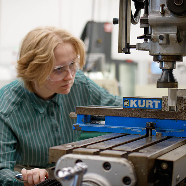 CNC student works with the equipment