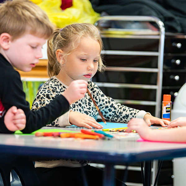 Young kids doing crafts in a classroom