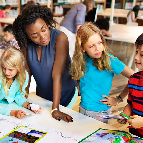 Teacher works with grade school kids