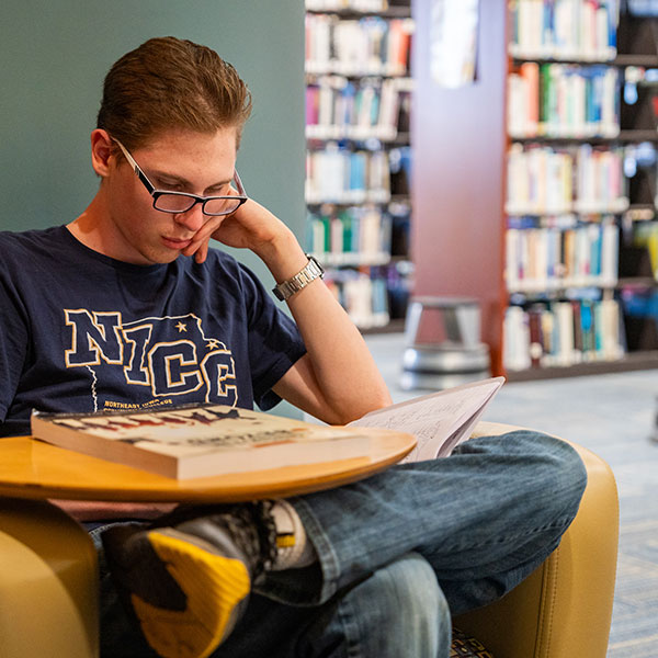 Male student studies in the library