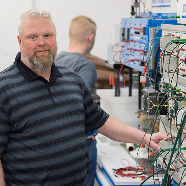 Student posing by equipment