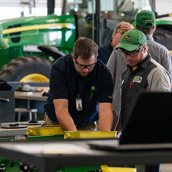 JDT students working in front of a tractor