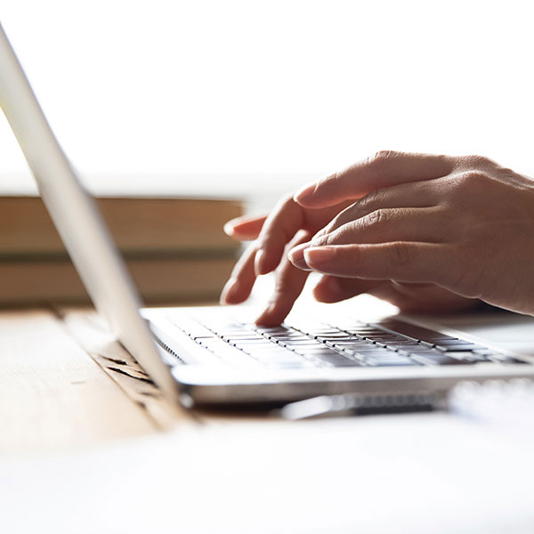 hands typing on a laptop