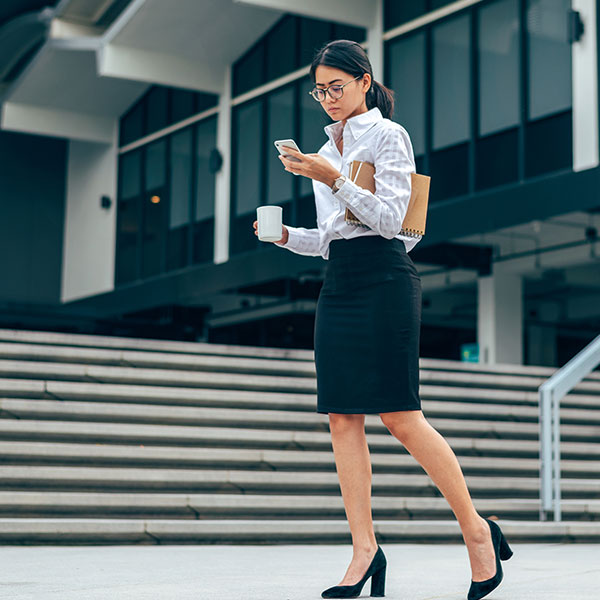 Female professional walking past an office building