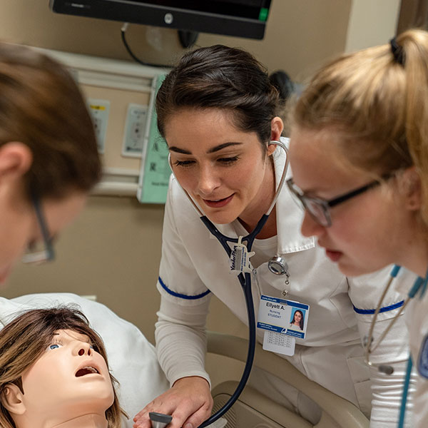 Nursing students working with a dummy