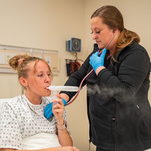 Student checking a patient's breathing