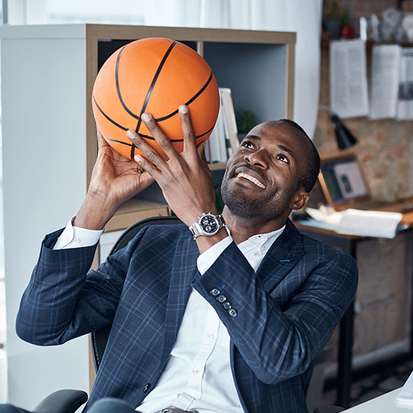 Businessman with a basketball in his office