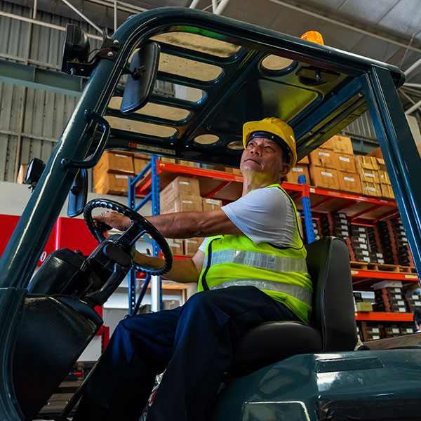 Male warehouse technician driving a forklift