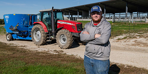 A female NICC student poses with a tractor