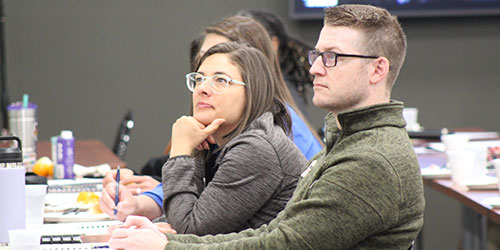 Business professionals listening to a presenter