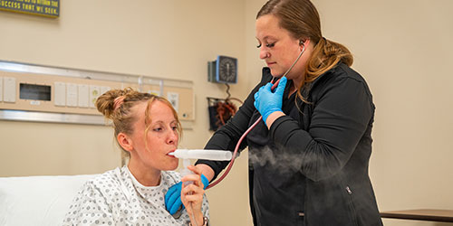 Respiratory care students practice in the health simulation lab.